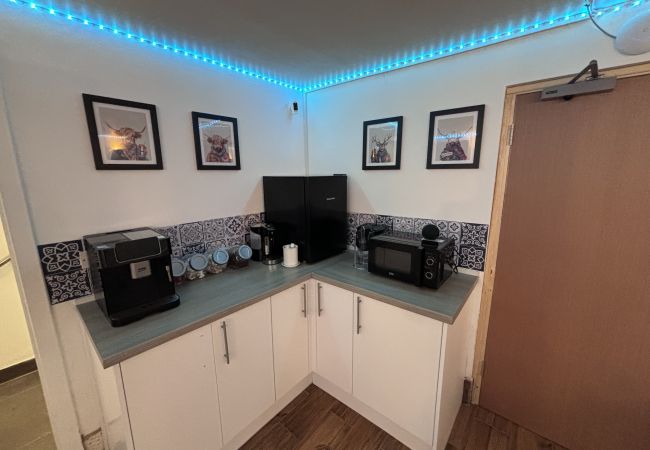 Haymarket Hostel kitchen in Edinburgh, equipped with microwave, kettle, and dining amenities